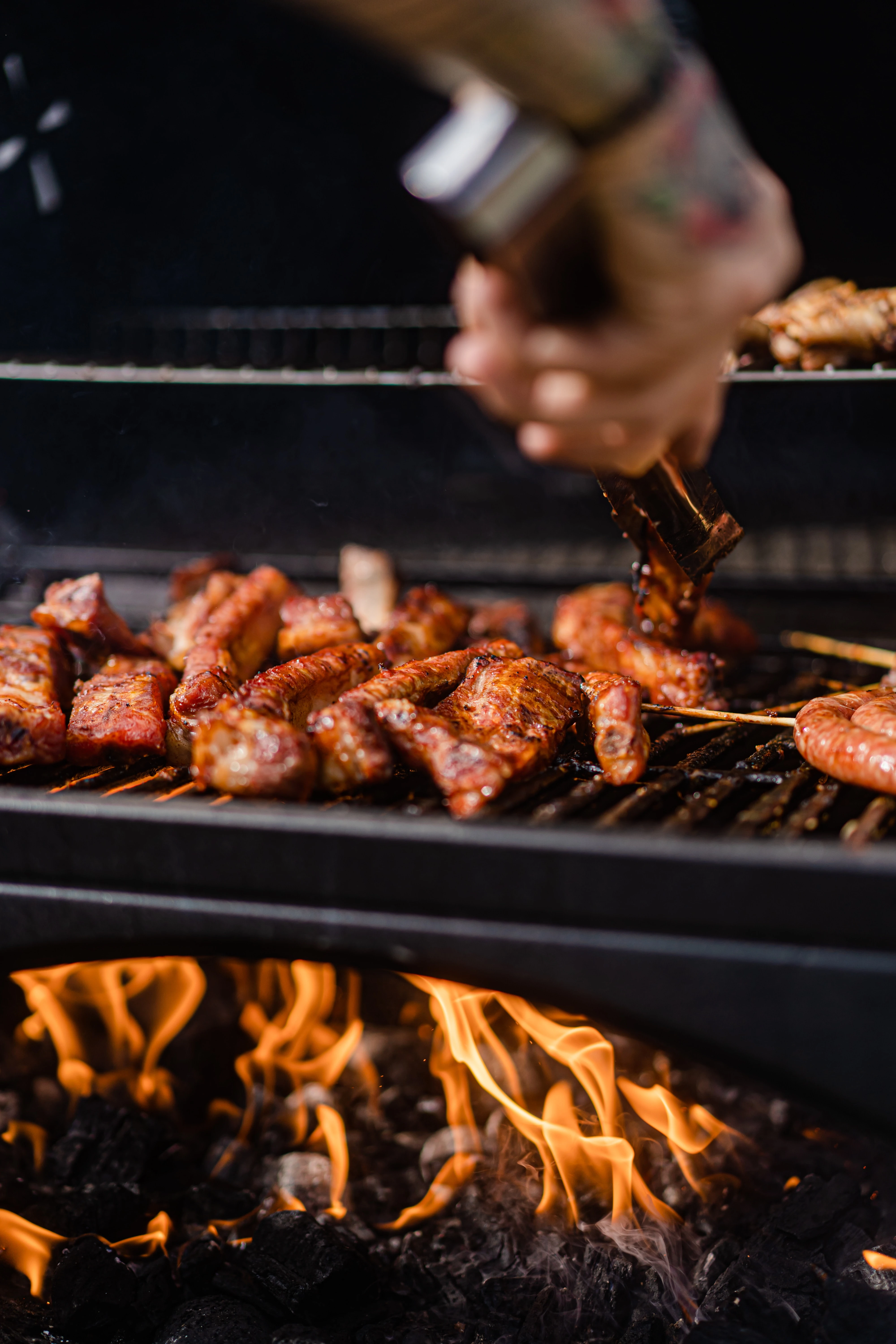 Schwarz & Hansen GmbH Fleisch auf einem Grill mit Feuer.